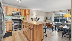 A modern kitchen with wooden cabinets, stainless steel appliances, and a central island.