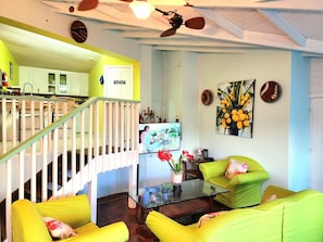 Cozy living area with a staircase, wall art, and comfortable seating.