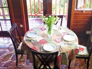 Enjoy meals with family and friends at this cozy dining table for four, surrounded by comfortable chairs and a touch of greenery.