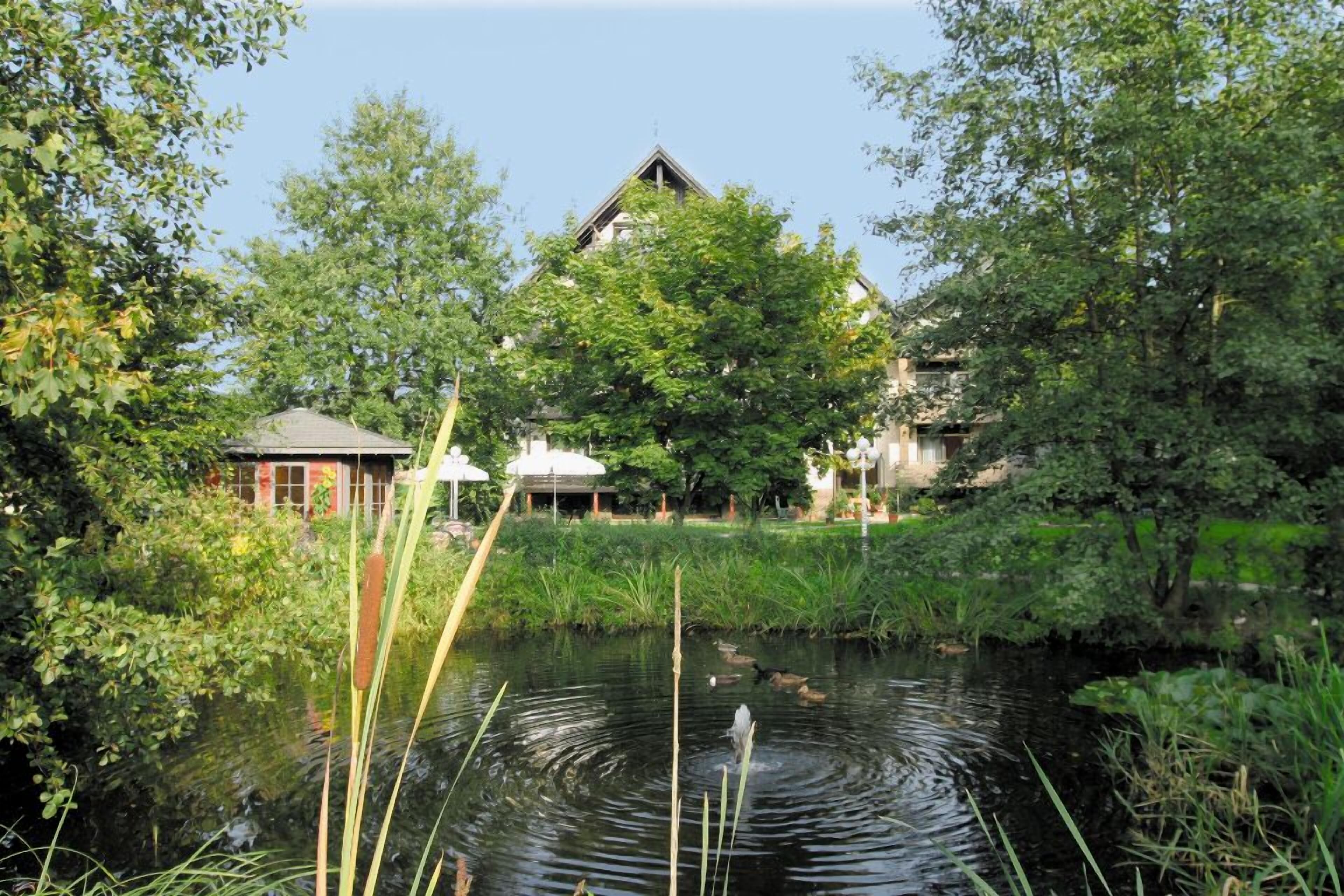 Eine friedliche Flusslandschaft mit einem Gebäude mit markantem Dach und einem kleinen Pavillon.