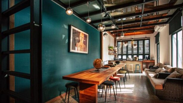 A modern interior with a wooden dining table, bar stools, a sofa, and a globe on the table. - Sweethome37 (New Taipei City)