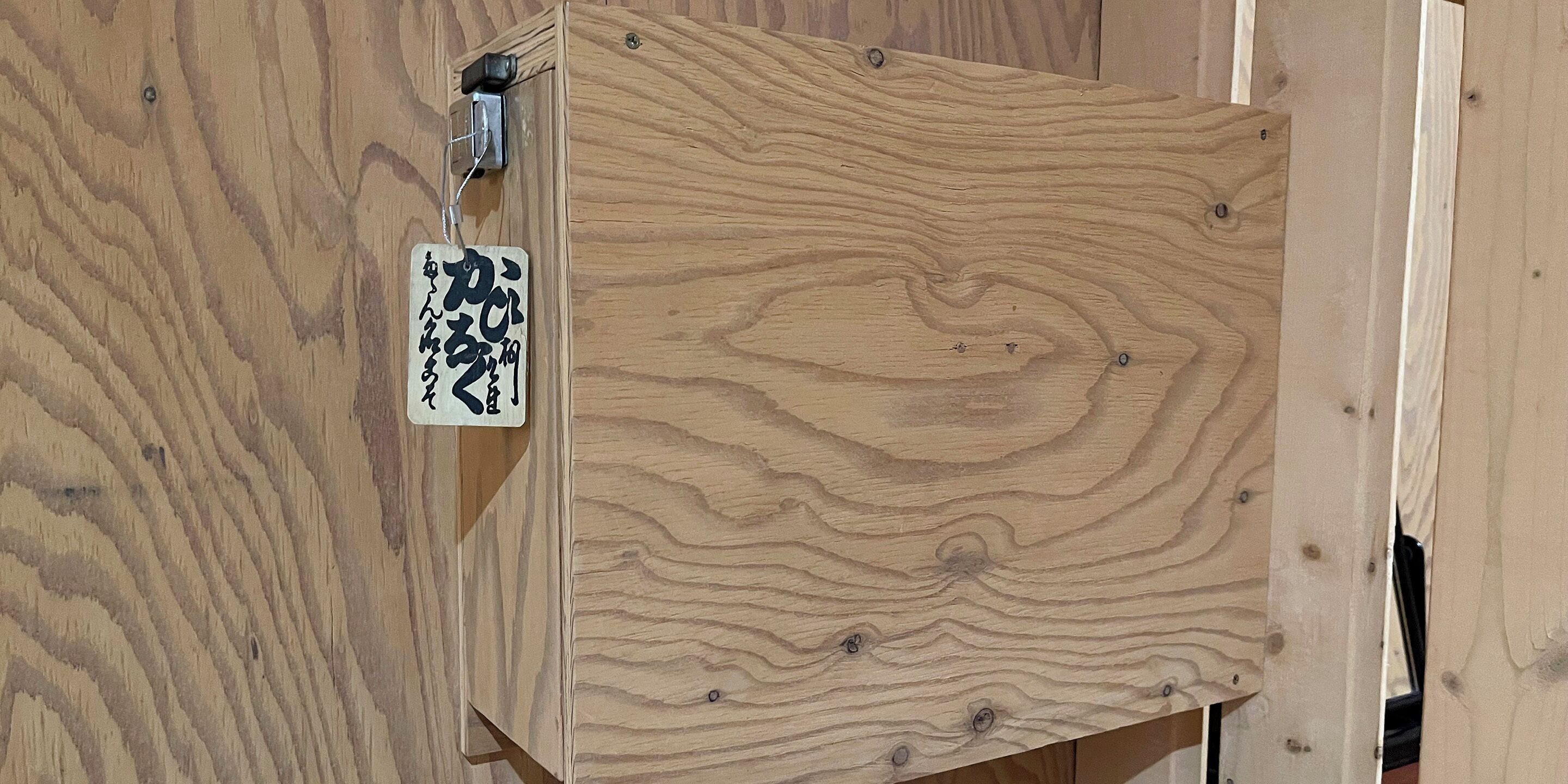 A wooden panel with a sign attached to it.