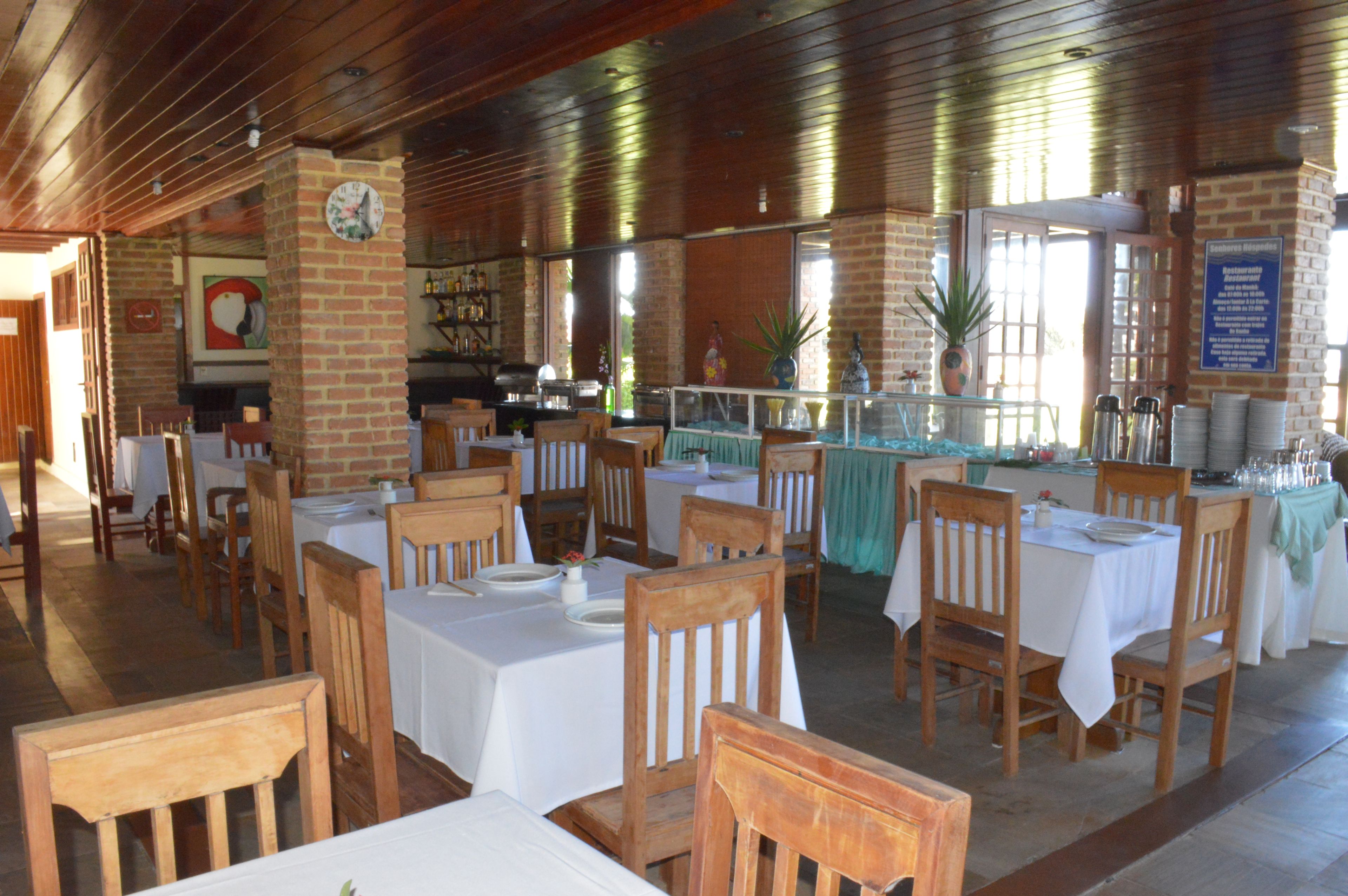 A restaurant with brick walls, wooden tables, and chairs.