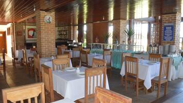 A restaurant with brick walls, wooden tables, and chairs.