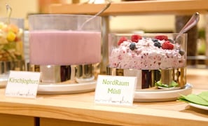 Un présentoir de desserts avec des articles étiquetés, notamment du « Kirschtjoghurt » et du « NordRaum Müsi ».