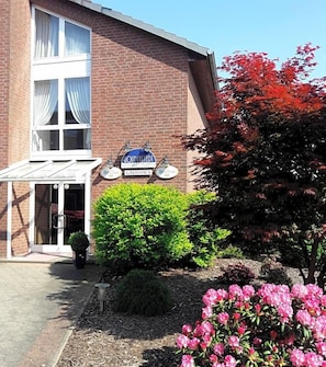 A brick building with a sign reading 'GASTHAUS' and a covered entrance.