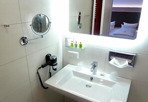 A hotel bathroom with a sink, mirror, and toiletries. - Hotel Restaurant Goldenstedt (Delmenhorst)