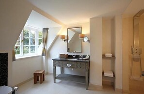 A modern bathroom with a vanity, a shower, and a large window.