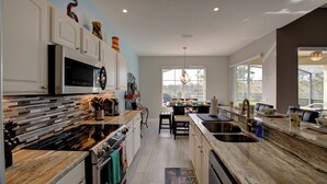 Una cocina moderna con una isla central, electrodomésticos integrados y un amplio ventanal que proporciona luz natural.