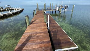 Une jetée en bois s’étendant dans des eaux calmes où la visibilité est excellente.