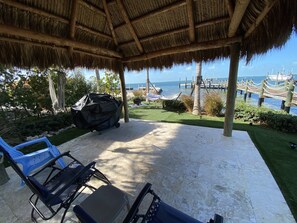 A covered patio with a view of the sea, a hammock, and a grill. - Bay Front Home With Magnificent Views  (Tavernier)