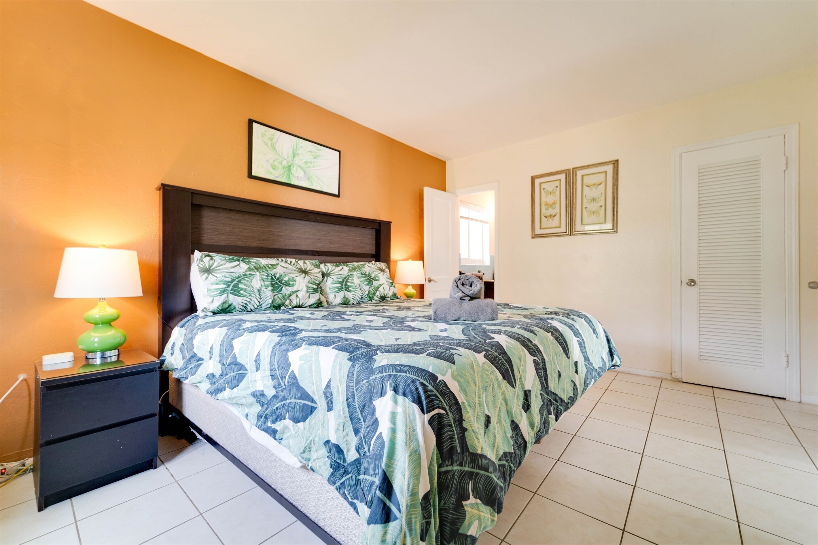 Une chambre à coucher avec un lit, des tables de chevet et une porte.