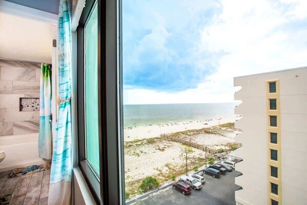 Une chambre avec vue sur la plage et sur le parking.