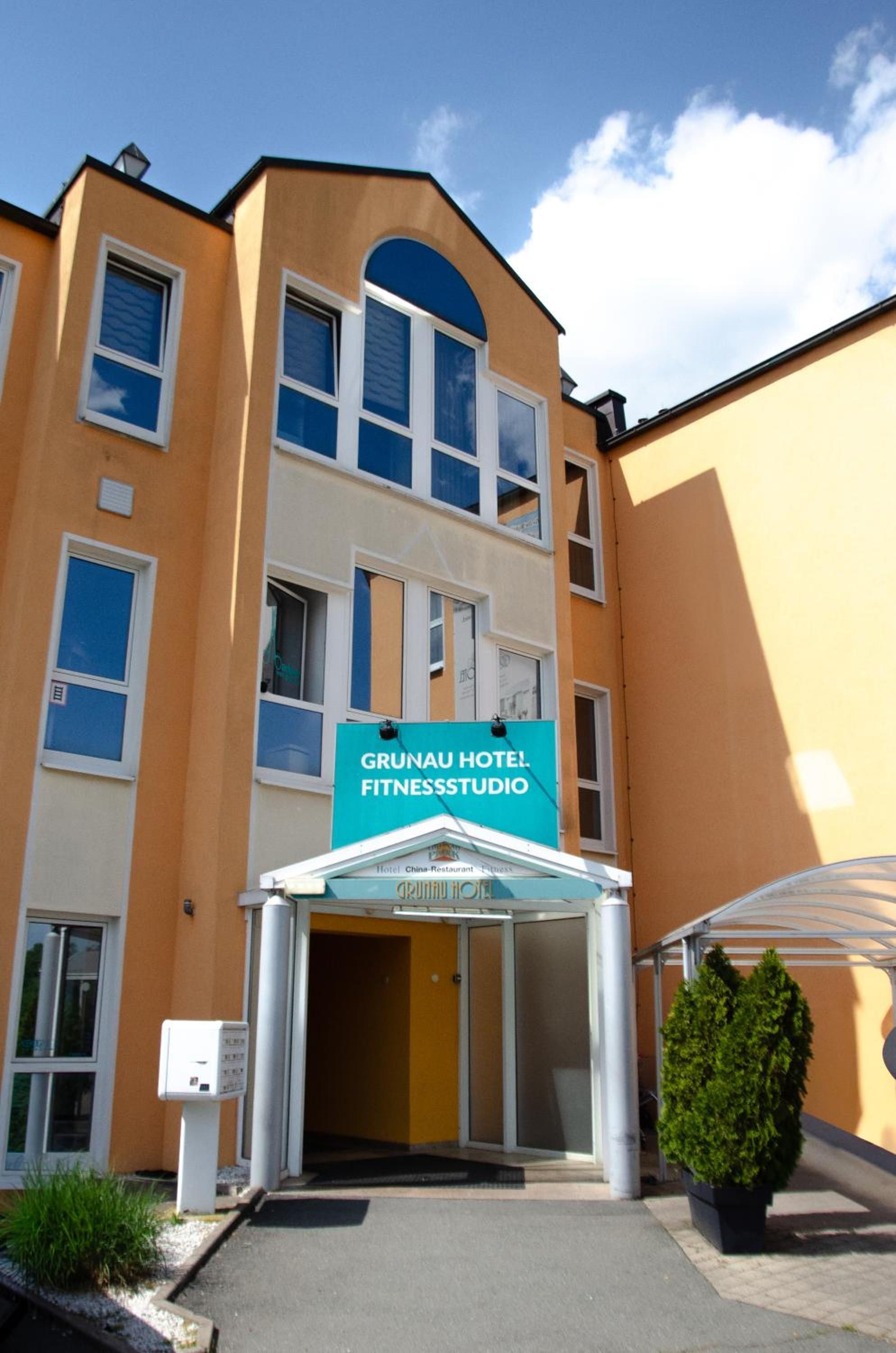Ein Hotel Eingang mit einem Schild für Grunau Hotel Fitnessstudio.