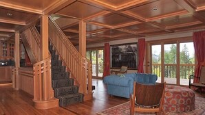 A spacious living area with a wooden staircase, a blue sofa, and a patterned rug. - Luxury On Mountain Ski Accommodation located between Alta and Snowbird (Alta)