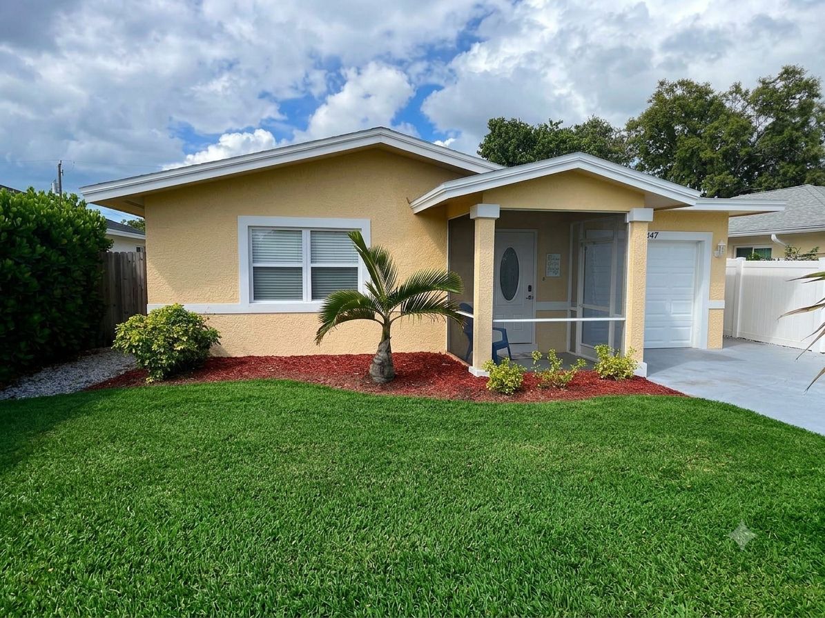 A single-story house with a front porch, a garage, and a well-maintained lawn.