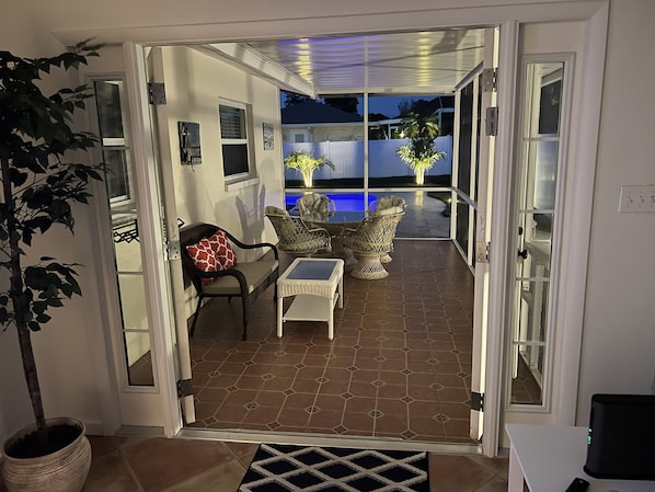 An open patio with a pool, outdoor furniture, and a view of the backyard.
