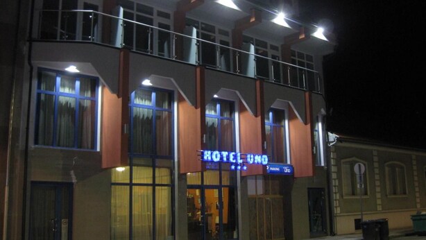 Un hotel con un letrero llamativo, múltiples ventanas y un balcón.