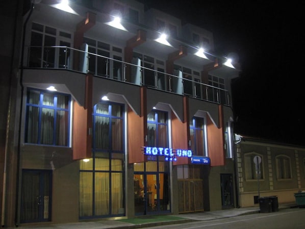 A hotel with a prominent sign, multiple windows, and a balcony.