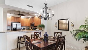 A modern kitchen with wooden cabinets, a built-in island, and a chandelier.