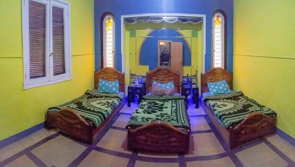 A room with two wooden beds, a window with shutters, and a mirror on the wall. - Isis Hotel Cairo (Cairo)