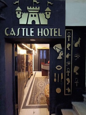 The entrance to the Castle Hotel with a sign featuring a castle and Egyptian symbols. - Isis Hotel Cairo (Cairo)