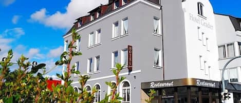 A hotel with a sign reading 'Hotel Grader' and a restaurant with a sign reading 'Restaurant'.