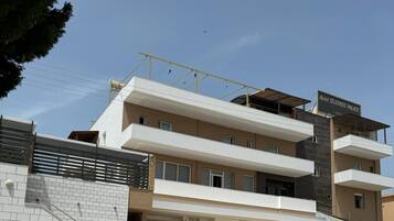 Un hôtel à plusieurs étages doté d’une architecture moderne, avec une entrée imposante, un escalier et un balcon situés aux étages supérieurs.