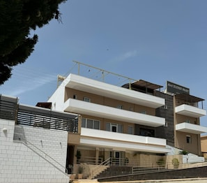 A multi-story hotel with a modern architectural design, featuring a prominent entrance with a staircase and a balcony on the upper floors. - Selefkos Palace (Igoumenitsa)