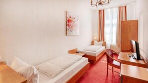 A hotel room with two beds, a desk, a chair, a TV, and a painting on the wall. - Hotel Restaurant Mathildenhof (Pulheim)