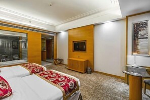 A hotel room with two beds, a wooden cabinet, a television, and a painting on the wall. - Guest Hotel of Luohe (Luohe)