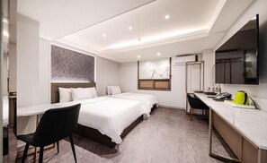 A hotel room with a bed, a desk, a chair, and a large mirror.