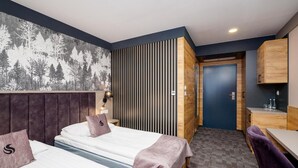 A hotel room with a bed, a desk, a chair, a wardrobe, and a door. - Hotel Scout (Czestochowa)