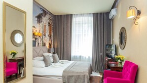 Een hotelkamer met een bed, een televisie, een bureau en een stoel.