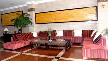 A spacious lobby with a sectional sofa, a coffee table, and a large abstract painting on the wall.