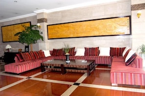 A spacious lobby with a sectional sofa, a coffee table, and a large abstract painting on the wall. - Jianchuan Hotel (Jianchuan)