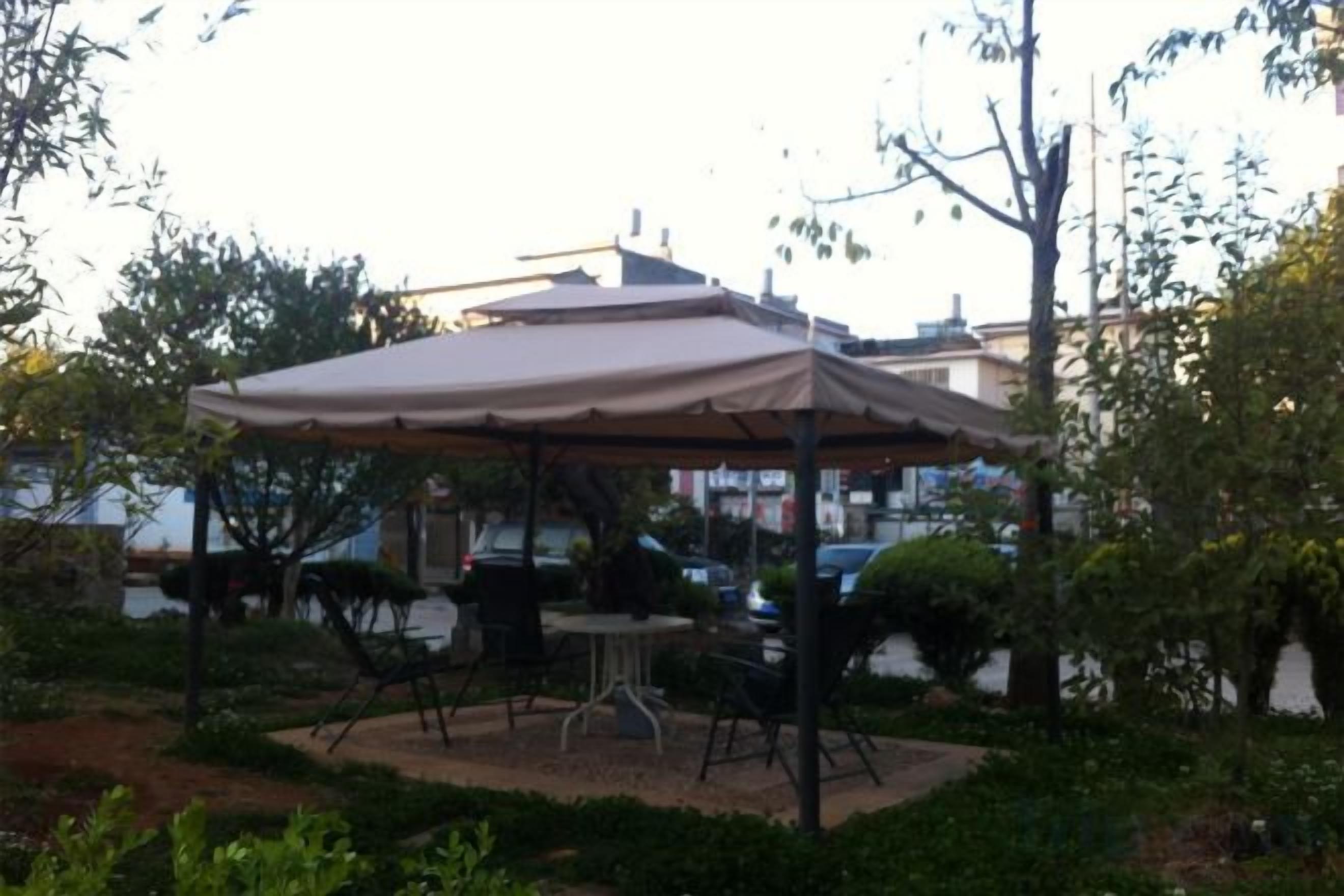 An outdoor seating area with a table and chairs under a canopy.