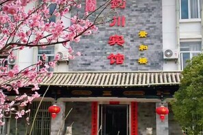 A building with a traditional Chinese architectural style, featuring a tiled roof and red lanterns.