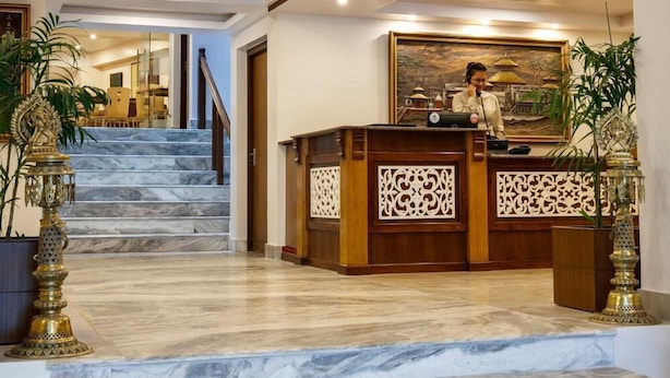 Eine Hotelhalle mit Marmorstufen, einem Empfangsbereich und einer Treppe zu einer weiteren Etage.