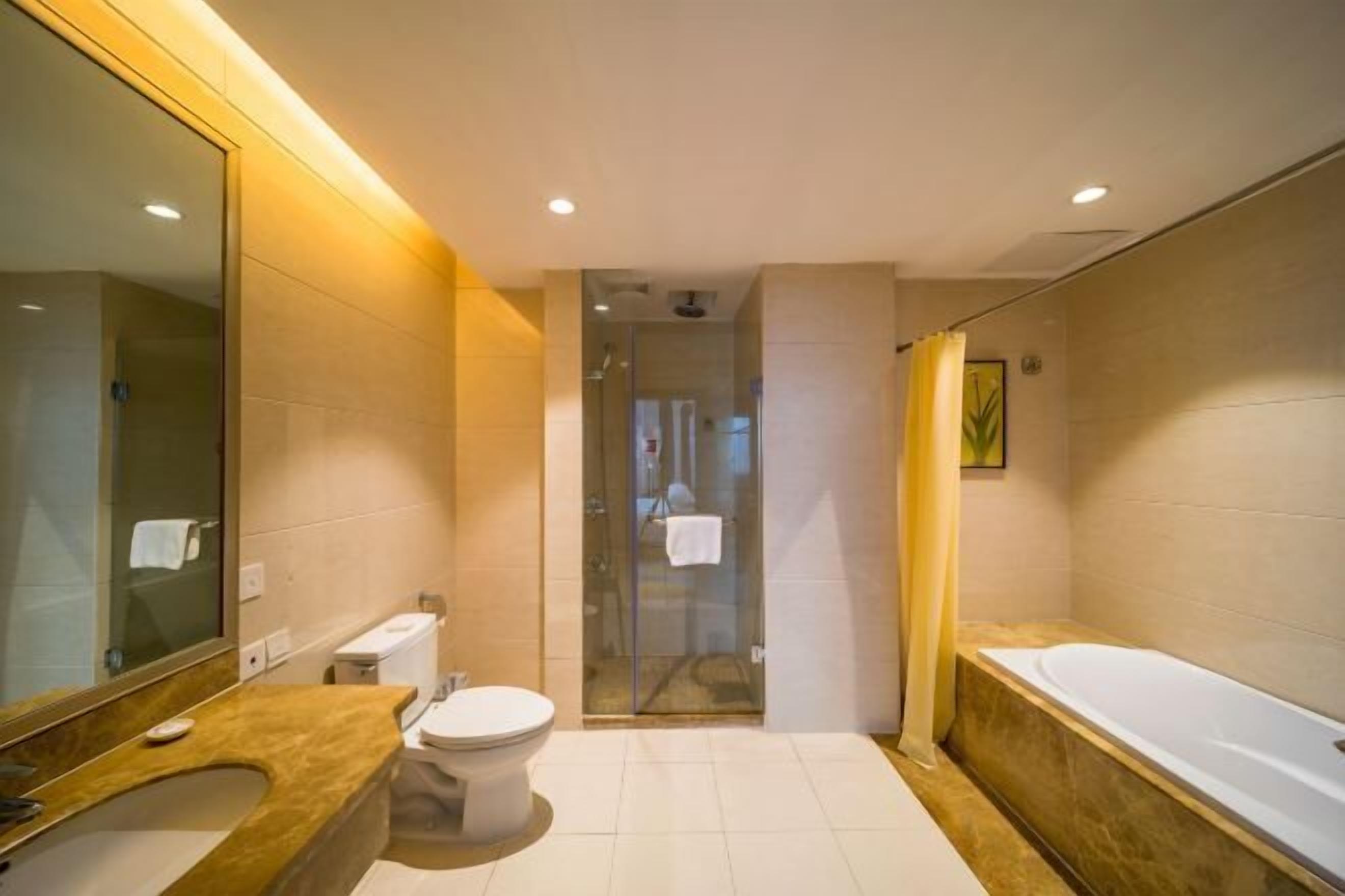 Ein modernes Badezimmer mit einem großen Spiegel, einer Badewanne, einer Toilette und einer Duschkabine.
