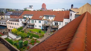 A residential area with multiple buildings, including a house with a visible staircase and a red-roofed building in the background. - Hotel Mirage (Duisburg)
