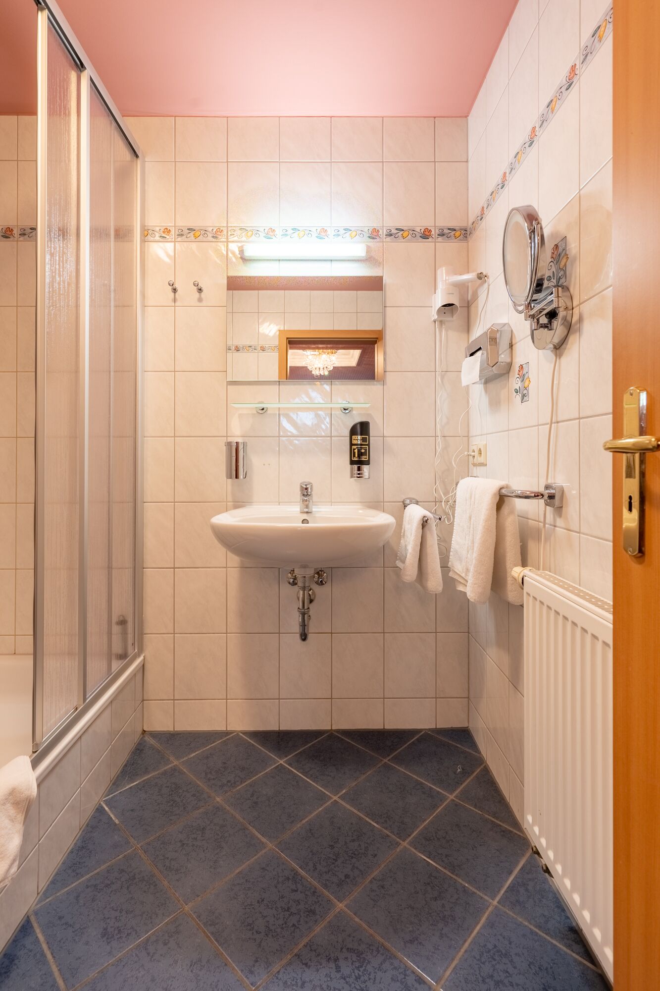A bathroom with a shower, sink, and toilet.