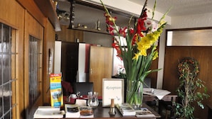 A reception desk with a framed welcome sign, a map stand, and a potted plant.