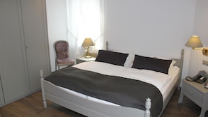 A hotel room with a single bed, a chair, two bedside tables with lamps, and a telephone. - Flair-goldener Stern (Ascheberg)