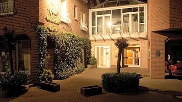 A hotel with a brick facade, a clock tower, and a well-lit entrance.