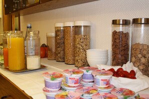 Un bufé de desayuno con diversos alimentos y bebidas.