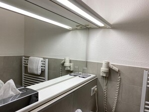 A bathroom with a towel rack, a hairdryer, and a mirror. - Hotel Flensburger Hof (Flensburg)