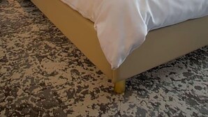 A hotel room with a large bed, a headboard with integrated lighting, a nightstand, and a patterned carpet. - Hotel Santo (Karlsruhe)