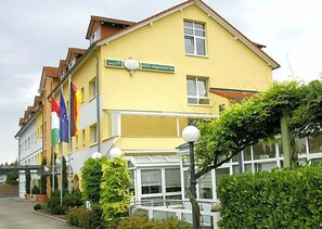 Un bâtiment jaune sur lequel on peut lire l’inscription : « HÔTEL Waghäusel Hof ».