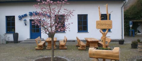 A building with a sign reading 'Zum Fisch' and a wooden signpost with 'Fahrkug' written on it.